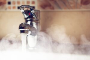 hot water pouring out of faucet with steaming water